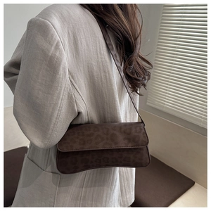 Detail of leopard print baguette bag with soft matte texture and retro flap design