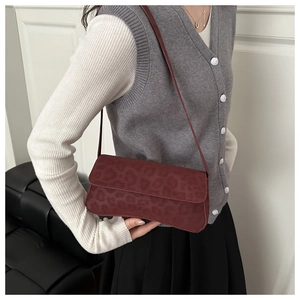 Detail of burgundy leopard print baguette bag featuring rectangular flap and slim strap