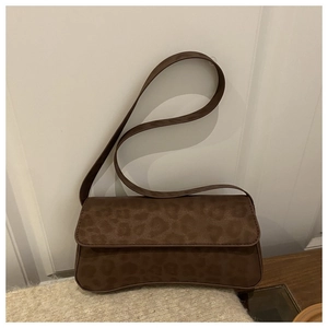 Close-up of leopard print baguette bag in matte suede texture with shoulder strap