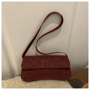 Detail of burgundy leopard embossed faux leather shoulder bag with flap closure