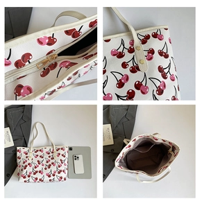 Detail view of large cherry print tote bag with golden zipper and interior compartments