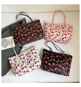 Detail of four colorful cherry print tote bags arranged with aesthetic lifestyle props
