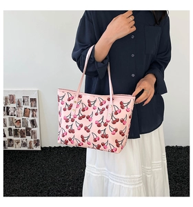 Detailed close-up of pink cherry print tote bag with premium leather texture and rivets