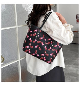 Detail of cherry pattern tote bag with gold hardware buckles and durable double straps