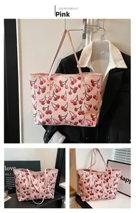 Detail of pink tote bag with cherry print pattern and durable metal rivet handles