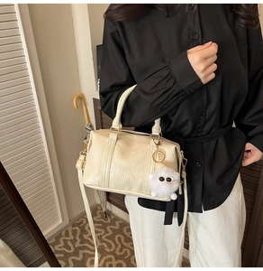 Sac Boston crème chic avec texture froissée et pendentif en peluche sur mannequin