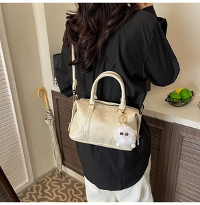 Detail of off-white pleated Boston bag with FASHION AIR PARIS embossing and plush charm
