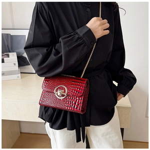 Dettaglio mini borsa bordeaux effetto coccodrillo con fibbia dorata e tracolla a catena