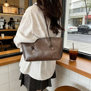 Vintage dark brown oil wax leather tote bag with elegant shoulder straps and metal hardware