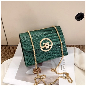 Dettaglio borsa a tracolla coccodrillo verde scuro con chiusura tonda dorata e catenina