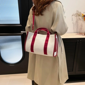 Minimalist cream canvas tote bag with contrast red handles and adjustable strap