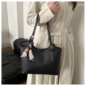 Close-up of black tote bag featuring white contrast stitching and vintage silk scarf detail