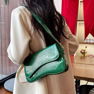 Green crocodile pattern glossy leather underarm baguette shoulder bag on a model