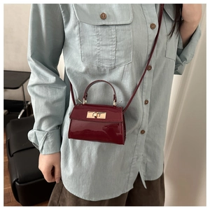 Mini wine red glossy patent leather crossbody bag with metal twist lock on model