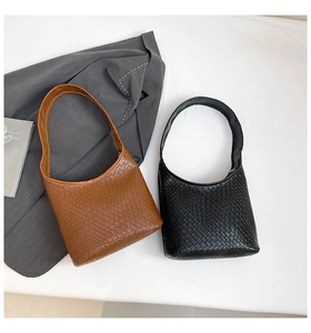 Detail of minimalist crocodile pattern shoulder bags in black and brown textured PU leather