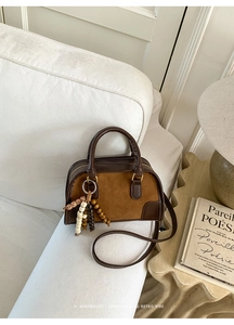Detail of vintage Boston bag with brown leather, suede texture and beaded charm decor
