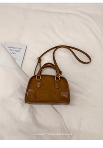 Detail of vintage brown leather handbag showing mixed suede texture and gold hardware