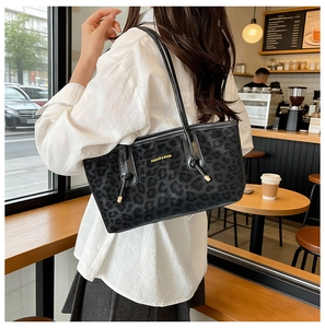 Détail du sac cabas léopard noir avec lettrage doré et finitions métalliques élégantes
