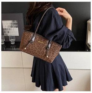 Sac fourre-tout tendance à motif léopard porté avec une robe bleu marine en intérieur