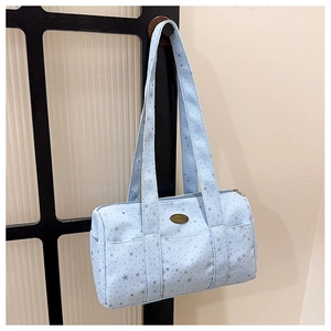 Detail of light blue cylinder shoulder bag with silver star patterns and metal logo