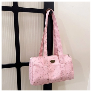 Detailed close-up of pink star pattern canvas bag with a handmade metal nameplate