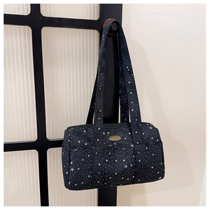 Detail of black canvas star pattern bag showing front pockets and metallic brand logo