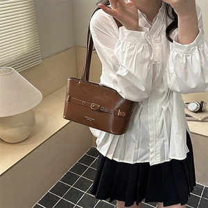 Vintage dark brown leather underarm bag with belt buckle detail shown on model
