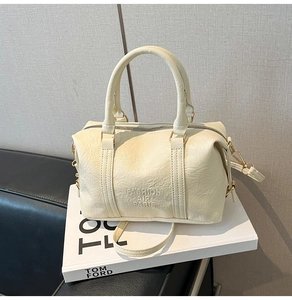Close-up of cream Boston handbag with Fashion Air Paris embossing and gold hardware