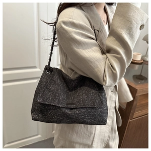 Gros plan sur un grand cabas en tweed gris foncé avec bandoulière chaîne et rabat
