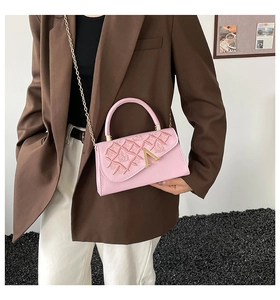 Sac à bandoulière rose avec fleurs en relief et boucle en V dorée sur un mannequin femme