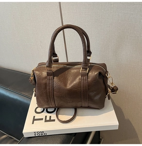 Close-up of dark brown litchi grain leather Boston bag with FASHION AIR PARIS logo