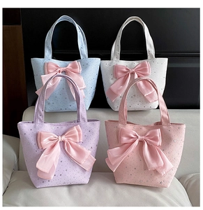 Four colorful canvas tote bags with satin bows and silver star patterns in a group display