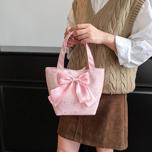 Detail of pink canvas tote bag featuring large satin bow and silver star patterns