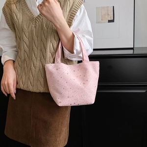 Detail of pink canvas tote bag featuring silver star patterns and sturdy double handles