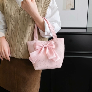 Pink canvas tote bag with star patterns and a large satin bow held by a model