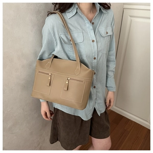 Gros plan du sac cabas kaki avec poches zippées et coutures contrastées blanches