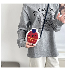 Detail of creative cupcake shaped crossbody bag with colorful patterns on a model