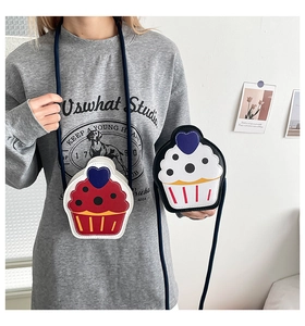 Detail view of a cute cupcake-shaped crossbody bag for girls in red and white colors