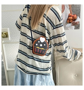 Close-up of a cute cupcake-shaped crossbody bag with heart detail and black cream top