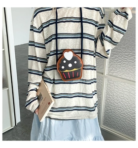 Detail view of children's cupcake-shaped crossbody bag with red stripes and heart detail