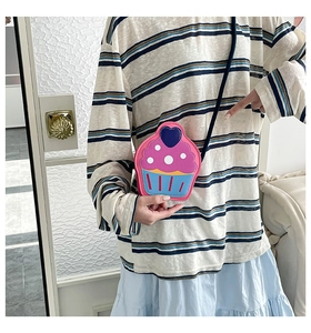 Detailed view of cupcake-shaped crossbody bag with pink and blue color-blocking design