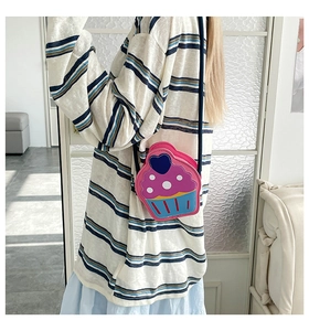 Detail of pink cupcake shaped crossbody bag with heart patterns and cake liner base