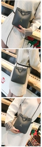 Detailed view of gray bucket bag with gold deer charm and magnetic snap closure