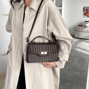 Brown woven leather handbag for women styled with a beige trench coat for a chic autumn look