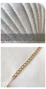 Macro detail of sparkly sequin texture and polished gold chain strap on shell-shaped bag