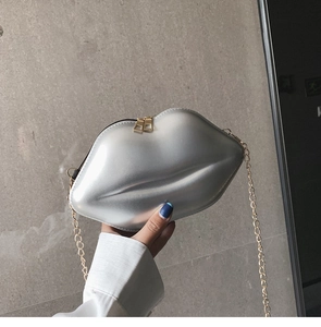 Detail shot of a silver lip-shaped bag with satin texture and golden metal chain strap