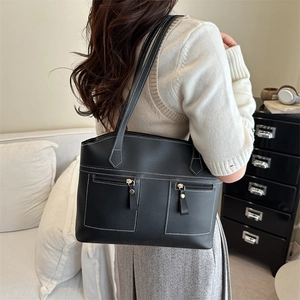 Sac fourre-tout noir classique avec surpiqûres blanches et poches zippées sur mannequin