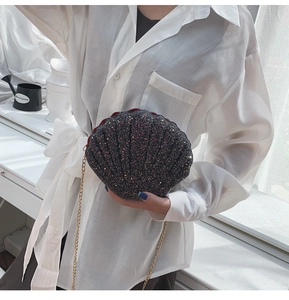 Detail of shell-shaped crossbody bag with colorful glitter surface and gold chain strap