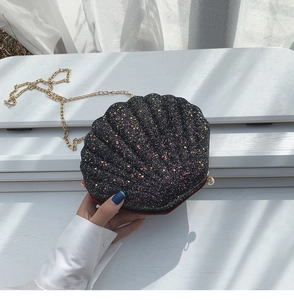 Detail of shell-shaped crossbody bag with iridescent sequins and gold chain strap