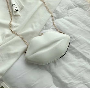 Close-up of a white lip-shaped crossbody bag with glossy finish and gold metal chain